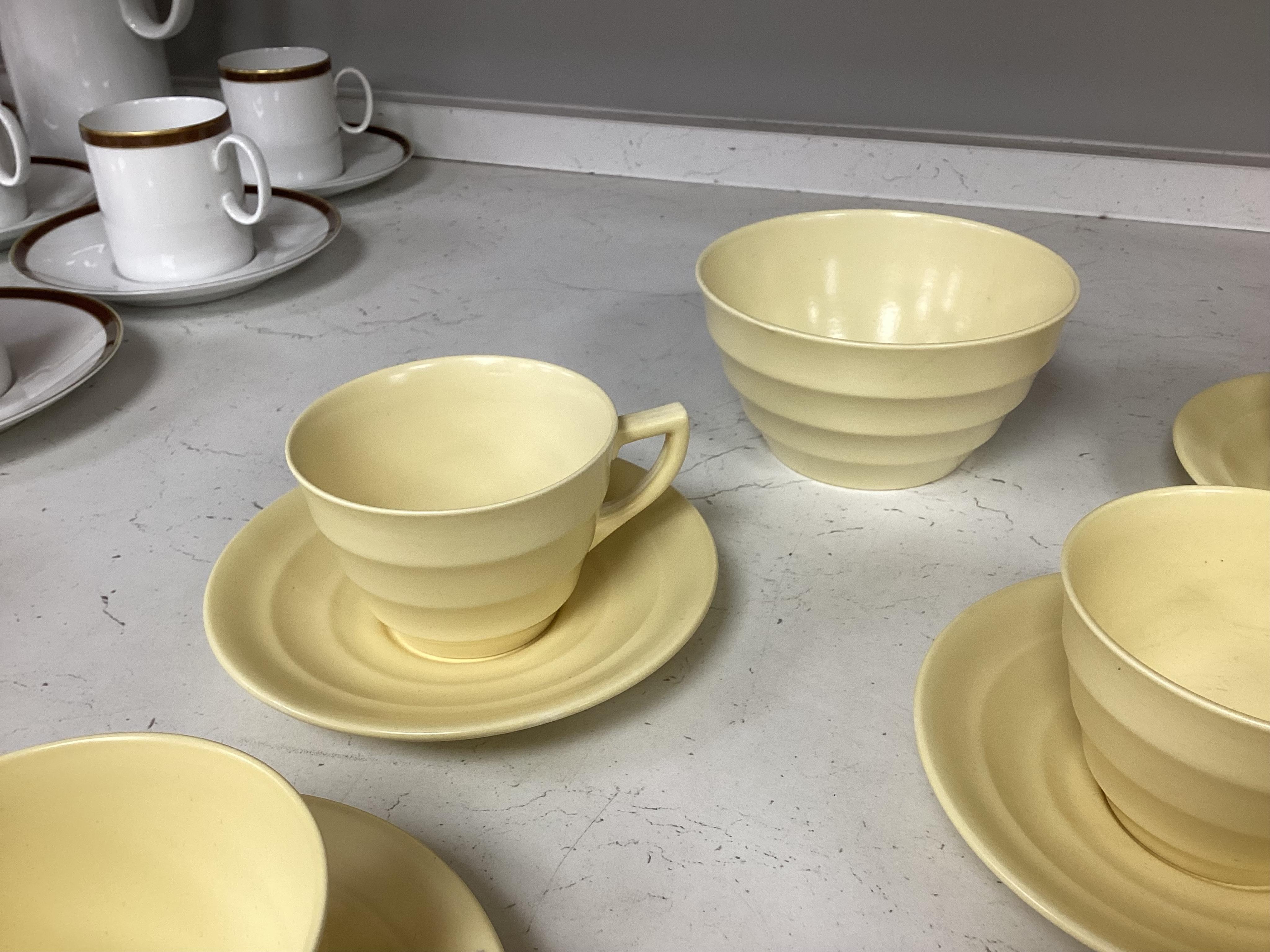 A part-set of Keith Murray Wedgwood teaware in matt straw, five cups and saucers, milk jug, sugar bowl and a spare saucer